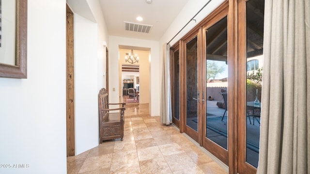 doorway to outside featuring french doors and an inviting chandelier