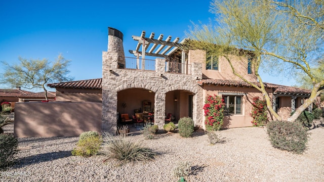 view of front of property with a balcony and a patio area