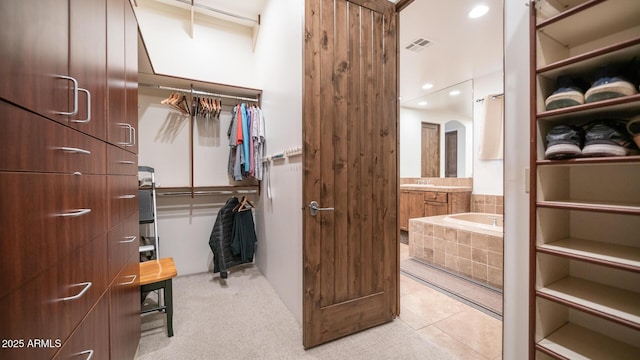 walk in closet featuring light tile patterned flooring