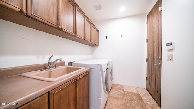 laundry area featuring cabinets, sink, and independent washer and dryer