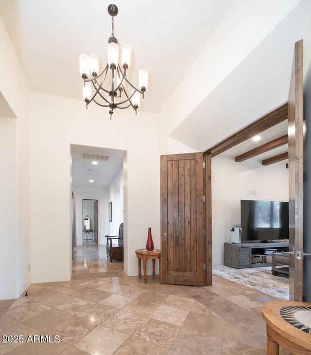 interior space with a notable chandelier and beamed ceiling