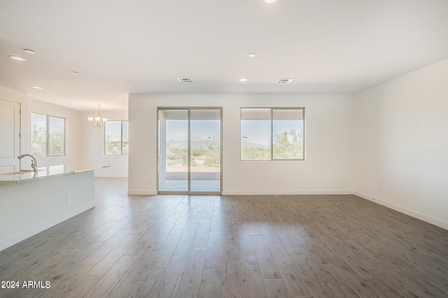 unfurnished room featuring wood finished floors, visible vents, and baseboards