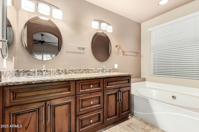 bathroom featuring double vanity, a sink, ceiling fan, and a bath