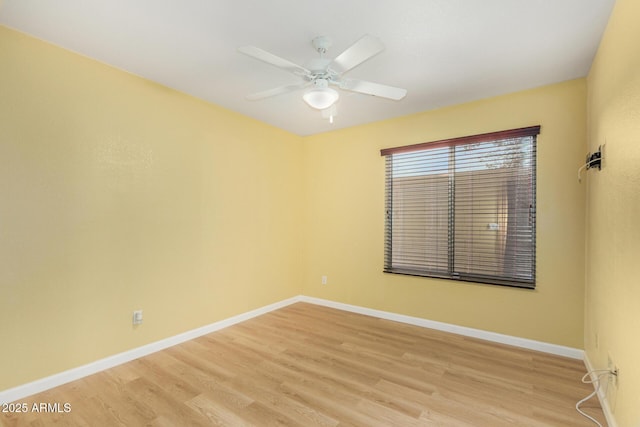 empty room featuring baseboards, ceiling fan, and light wood-style flooring