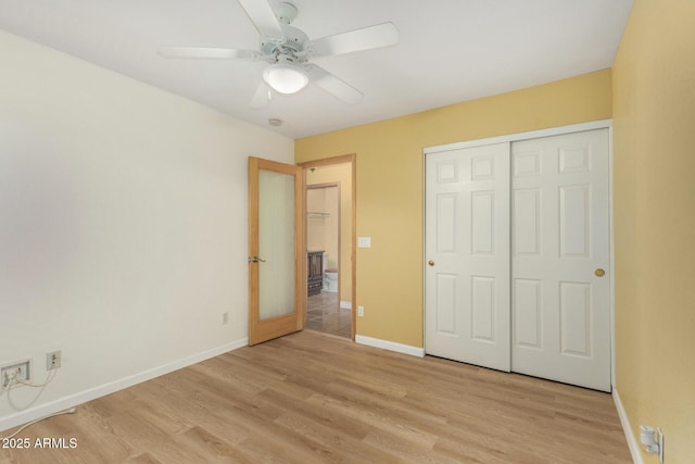unfurnished bedroom with baseboards, a ceiling fan, a closet, and light wood-style flooring