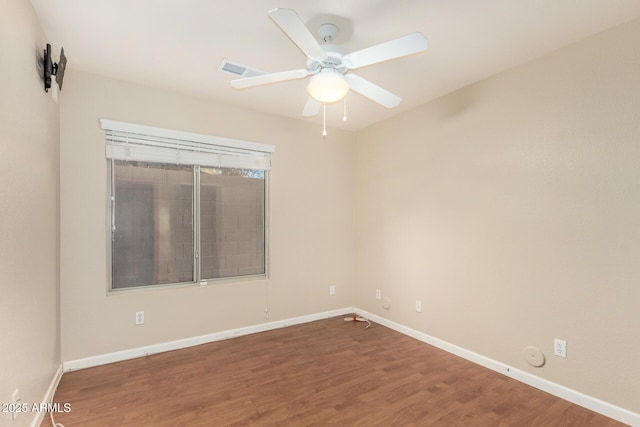 unfurnished room with baseboards, a ceiling fan, wood finished floors, and visible vents