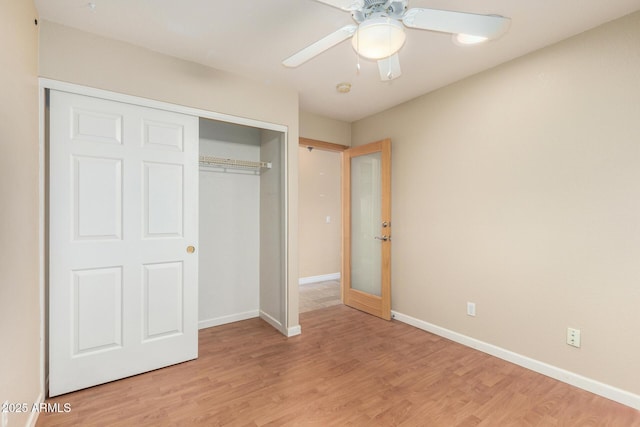 unfurnished bedroom with baseboards, a ceiling fan, light wood finished floors, and a closet