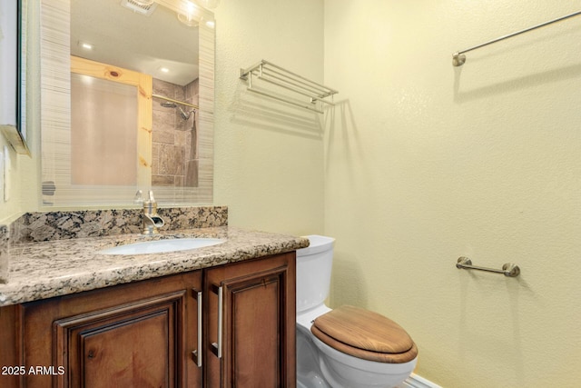 bathroom with vanity, toilet, and a shower