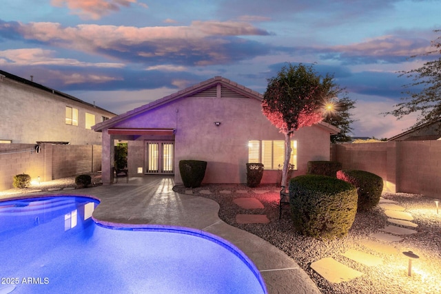 view of pool featuring a fenced in pool, a fenced backyard, french doors, and a patio