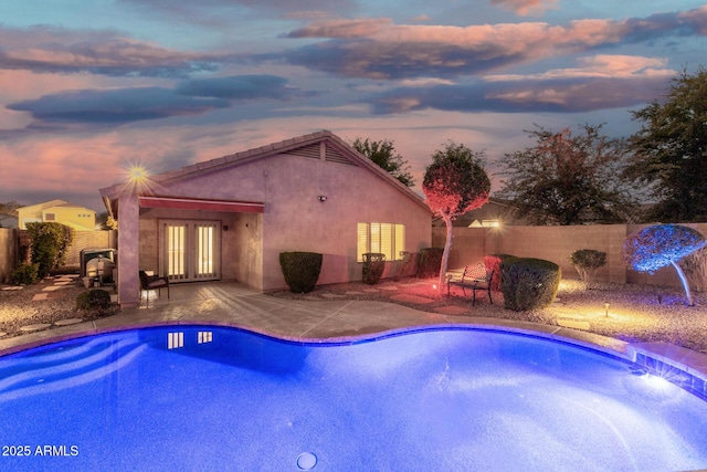view of pool featuring a patio, a fenced in pool, french doors, and a fenced backyard
