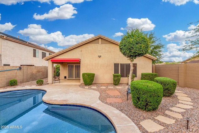 exterior space with a fenced in pool, a fenced backyard, a patio area, and stucco siding
