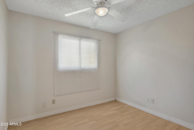 empty room with ceiling fan, a textured ceiling, and light wood-type flooring