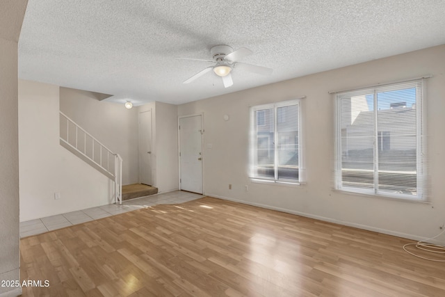 interior space with ceiling fan, light hardwood / wood-style flooring, and a textured ceiling