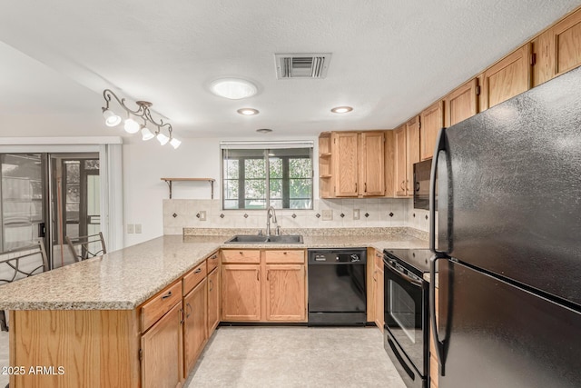 kitchen featuring tasteful backsplash, kitchen peninsula, sink, and black appliances