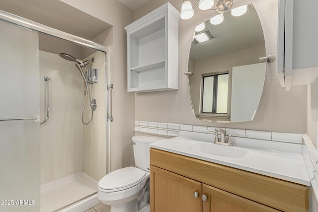 bathroom featuring vanity, a shower with door, and toilet