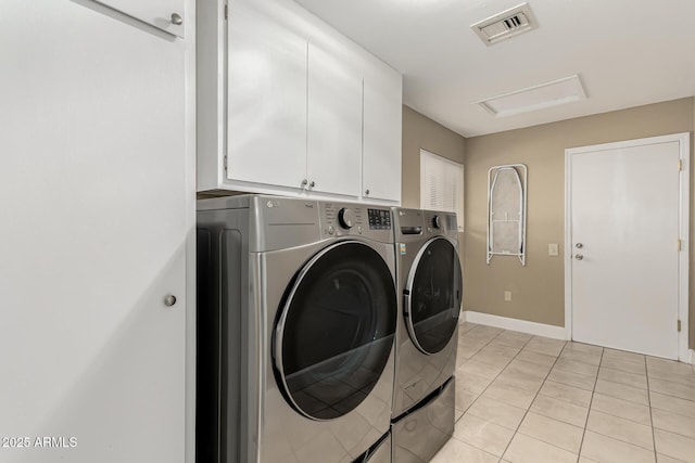 laundry room featuring cabinets, light tile patterned floors, and independent washer and dryer