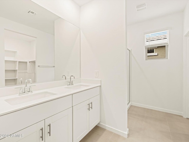 full bathroom featuring double vanity, visible vents, baseboards, and a sink