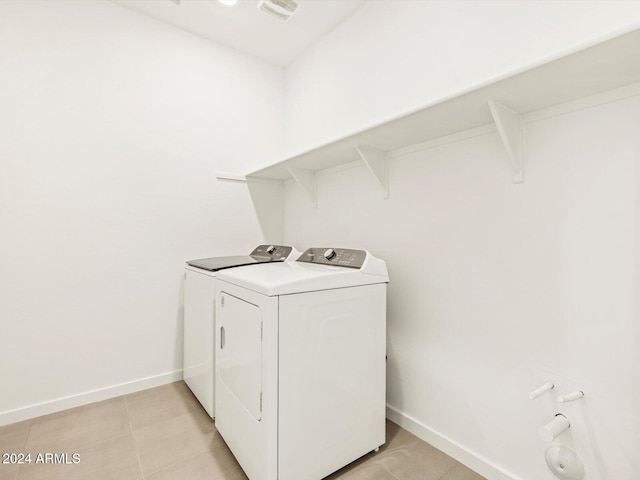 laundry room with visible vents, baseboards, light tile patterned floors, laundry area, and separate washer and dryer