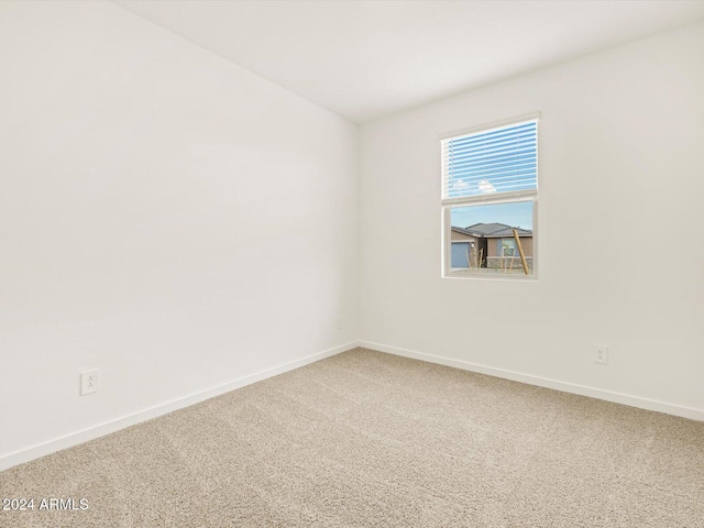 empty room featuring baseboards and carpet flooring