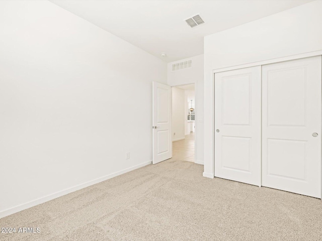 unfurnished bedroom with visible vents, baseboards, carpet, and a closet