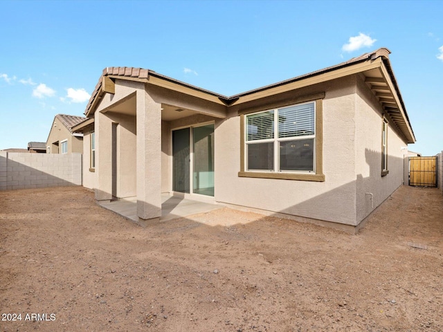 rear view of property featuring stucco siding and a fenced backyard