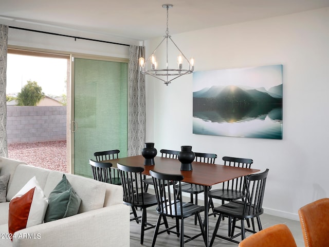 dining space with baseboards and a chandelier