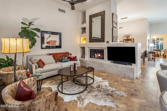 living room with a premium fireplace and a ceiling fan