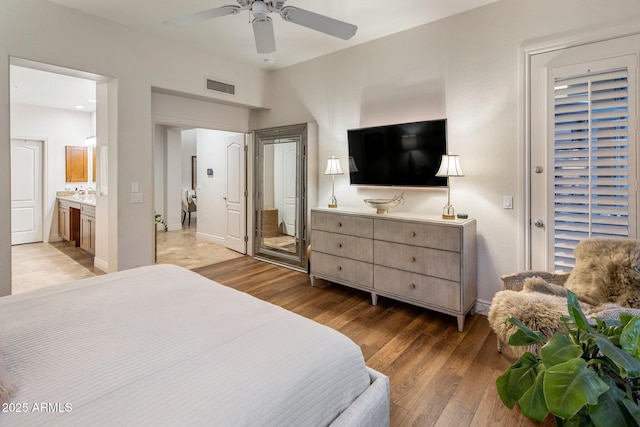 bedroom with light wood-type flooring, baseboards, ensuite bath, and a ceiling fan