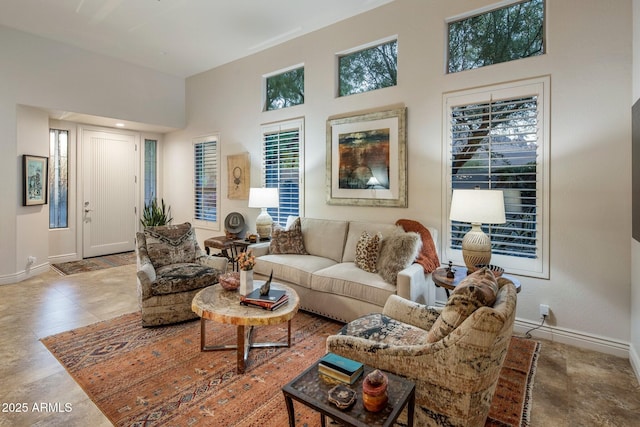 living room with baseboards and a high ceiling