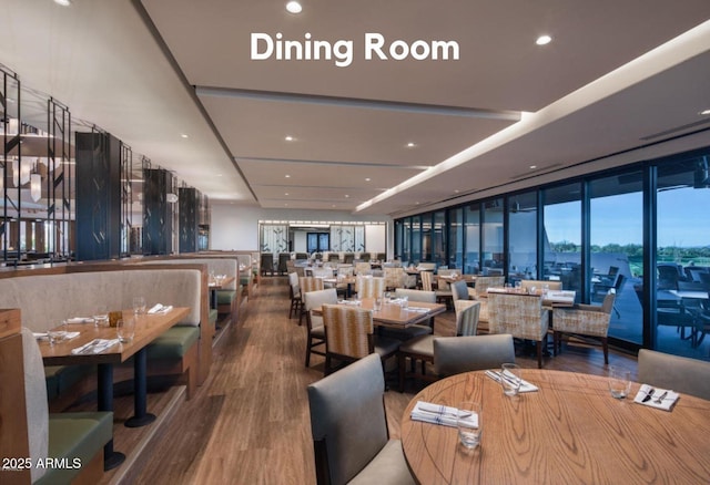 dining area with wood finished floors, floor to ceiling windows, and recessed lighting