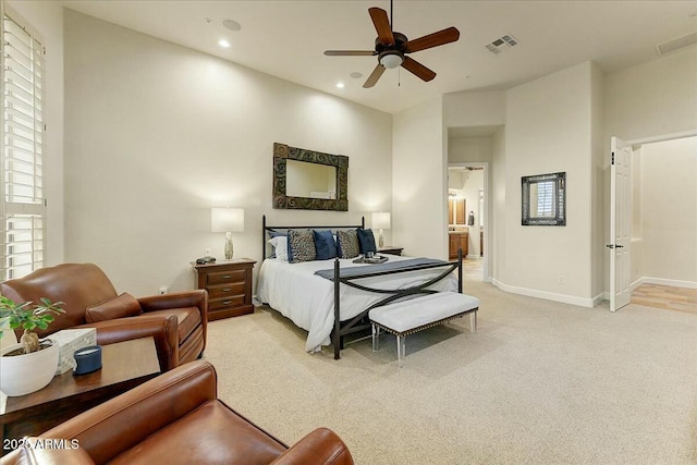 bedroom with light carpet, connected bathroom, and ceiling fan