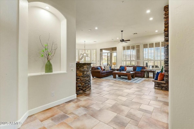 interior space featuring ceiling fan with notable chandelier