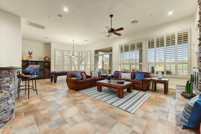 living room featuring ceiling fan with notable chandelier and billiards