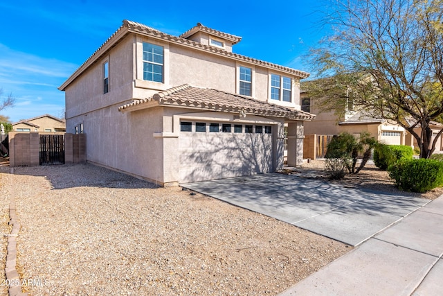 view of front of property featuring driveway, a tiled roof, fence, and stucco siding