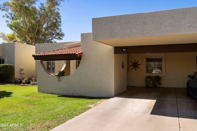 doorway to property with a yard and a carport