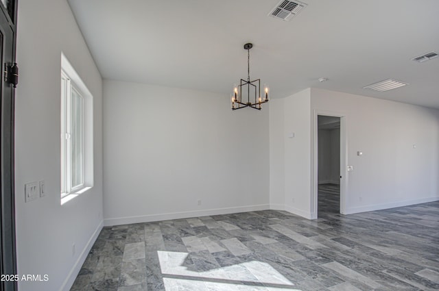 spare room with a chandelier