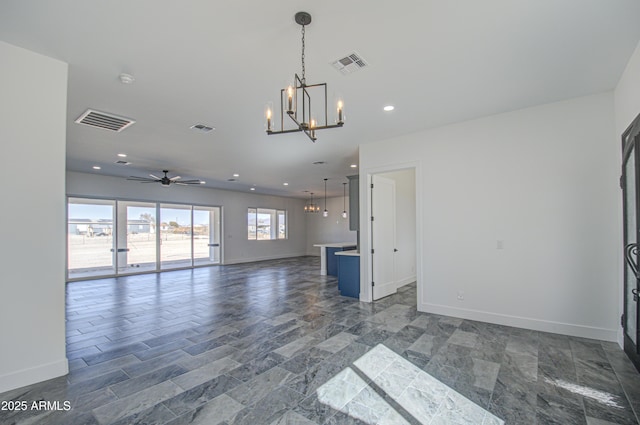 unfurnished living room featuring ceiling fan with notable chandelier