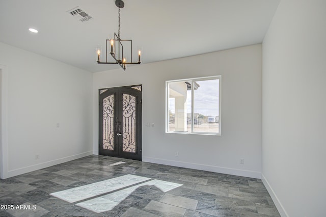 foyer entrance featuring an inviting chandelier and french doors