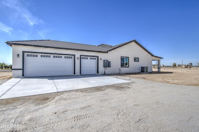 view of front of home with central air condition unit and a garage