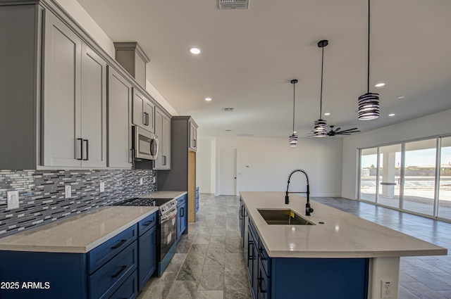 kitchen with stainless steel appliances, decorative light fixtures, blue cabinets, sink, and decorative backsplash