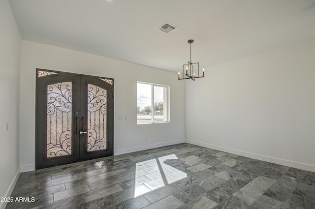 foyer with french doors and a notable chandelier