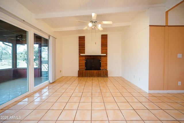unfurnished living room with light tile patterned floors, a fireplace, vaulted ceiling with beams, and ceiling fan