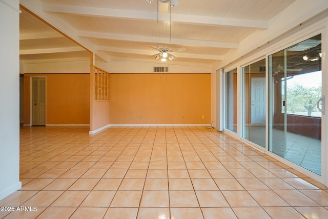 spare room with lofted ceiling with beams, light tile patterned floors, a ceiling fan, and baseboards