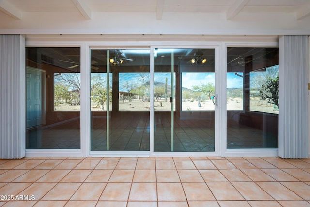 spare room featuring beam ceiling and light tile patterned floors