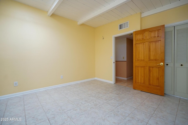 unfurnished room featuring beam ceiling, visible vents, and baseboards
