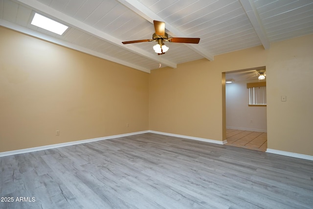 empty room featuring baseboards, ceiling fan, beamed ceiling, wooden ceiling, and wood finished floors