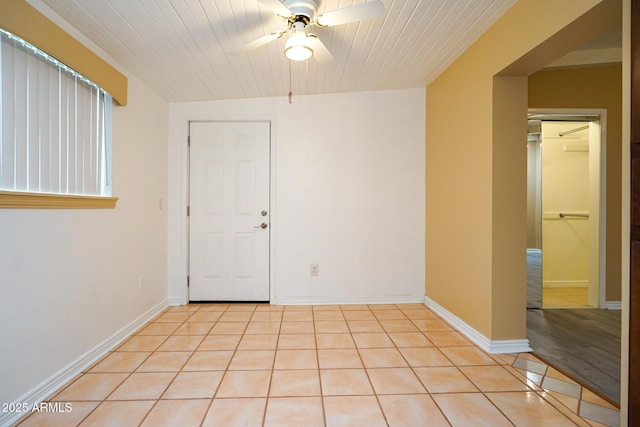 spare room featuring light tile patterned floors, baseboards, and a ceiling fan