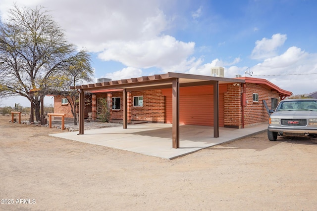 rear view of property featuring an attached carport and brick siding