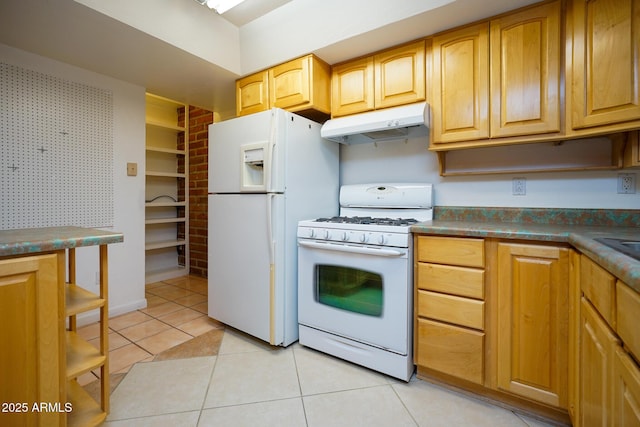 kitchen featuring white appliances, light tile patterned floors, dark countertops, and under cabinet range hood
