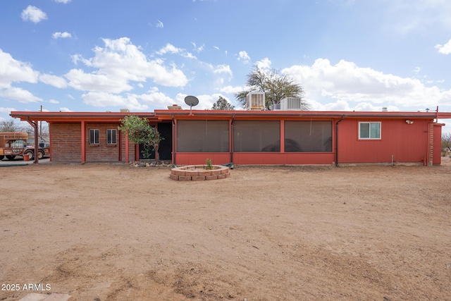 rear view of house with cooling unit and a sunroom